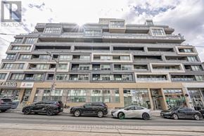 Toronto (Wychwood) condo for rent - A modern multi-story building with cars parked in front.