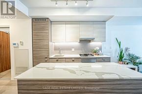 Toronto (Wychwood) condo for rent - A modern kitchen with a large island in the middle.