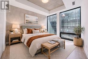Toronto (Moss Park) condo for rent - A bedroom with a large bed and a view of the city.