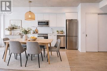 Toronto (Moss Park) condo for rent - A modern kitchen with a dining table set for four.