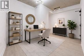 Toronto (Moss Park) condo for rent - A well-lit office space with a desk, chair, and shelving unit.
