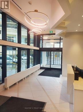 Toronto (Willowdale West) condo for rent - The image shows the lobby of a building with a reception desk and a large window.