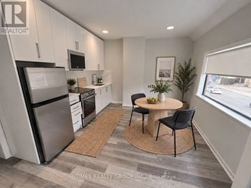 Toronto (Church-Yonge Corridor) multi-family for rent - A modern kitchen with a dining table and chairs.