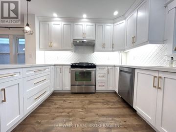 Toronto (East End-Danforth) apartment for rent - A kitchen with white cabinets and a wooden floor.