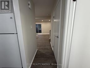 Ottawa townhouse for rent - A hallway with a door on the right and a window in the distance.