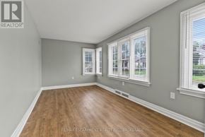 St. Catharines (Downtown) duplex for rent - A room with wooden floors and two windows.