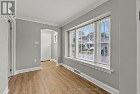 St. Catharines (Downtown) duplex for rent - A room with a large window and wooden flooring.