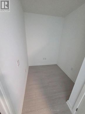 Toronto (Humber Heights) condo for rent - A white room with a wooden floor and a white wall.
