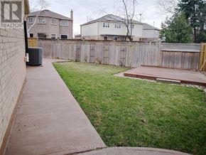 Mississauga (Lisgar) apartment for rent - A backyard with a wooden deck and a fence.