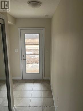 Thorold (Hurricane/Merrittville) townhouse for rent - A white door in a hallway with a view of a snowy landscape outside.