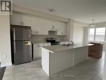 Thorold (Hurricane/Merrittville) townhouse for rent - A kitchen with white cabinets and a stainless steel refrigerator.