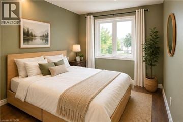 Stoney Creek townhouse for rent - A bedroom with a large bed and a window with curtains.