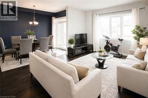 Stoney Creek townhouse for rent - A living room with a white sofa, a glass coffee table, and a TV.