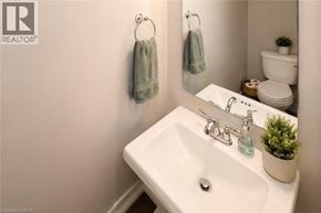 Stoney Creek townhouse for rent - A white sink in a bathroom with a mirror and towel rack.