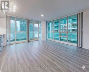 Toronto (Waterfront Communities) condo for rent - A spacious room with wooden flooring and large windows.
