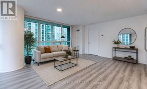 Toronto (Waterfront Communities) condo for rent - A spacious living room with a large window, a sofa, a coffee table, and a side table.