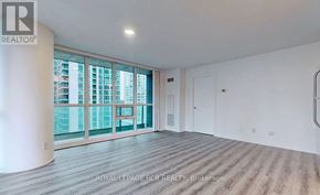 Toronto (Waterfront Communities) condo for rent - A spacious room with a large window overlooking a cityscape.