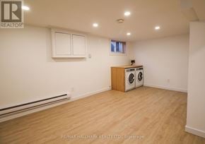 Toronto (South Riverdale) townhouse for rent - A room with a wood floor, a window, and a wall-mounted heater.