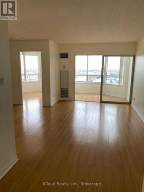 Mississauga (Cooksville) condo for rent - A room with wooden floors and a view of the city through the windows.