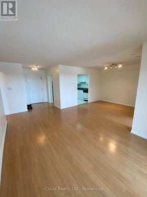 Mississauga (Cooksville) condo for rent - A spacious room with wooden flooring and white walls.