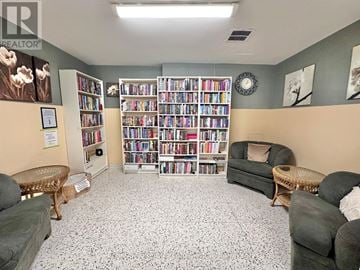 St. Catharines (Glendale/Glenridge) condo for rent - A living room with a bookshelf and a couch.