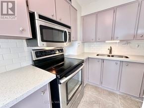 St. Catharines (Glendale/Glenridge) condo for rent - A kitchen with pink cabinets and a white countertop.