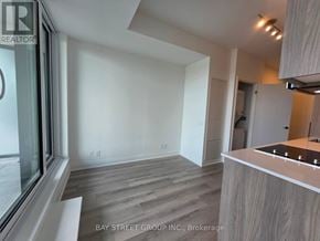 Toronto (Clairlea-Birchmount) condo for rent - A modern kitchen with a wooden floor and white walls.