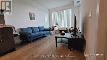 Toronto (Willowdale East) condo for rent - A living room with a blue couch and a television.