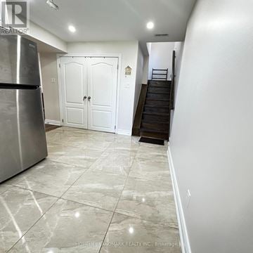 Toronto (Dorset Park) apartment for rent - A kitchen with a refrigerator and a staircase.