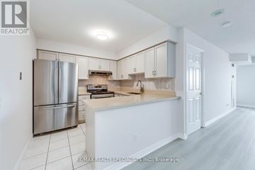 Mississauga (Hurontario) condo for rent - A kitchen with white cabinets and a stainless steel refrigerator.