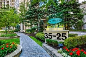 Mississauga (Hurontario) condo for rent - A sign for SkyRark apartments is displayed in front of a landscaped area.