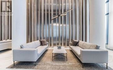 Mississauga (City Centre) condo for rent - A modern living room with two white sofas and a coffee table.