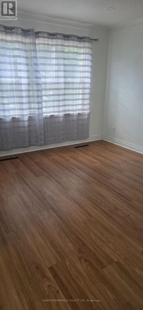 Toronto (West Hill) apartment for rent - A room with wooden flooring and a window with curtains.