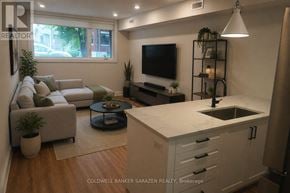 Ottawa apartment for rent - A modern kitchen with a white countertop and a flat screen TV mounted above it.