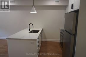 Ottawa apartment for rent - A kitchen with a white island and a black refrigerator.