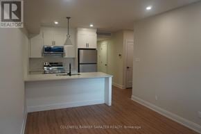 Ottawa apartment for rent - A kitchen with a stainless steel refrigerator and a stove top oven.