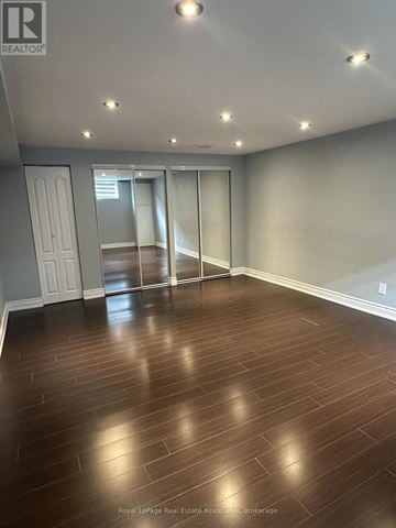 Mississauga (Dixie) apartment for rent - A spacious room with wooden flooring and sliding glass doors.