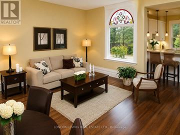 London South (South F) apartment for rent - A living room with a couch, two chairs, a coffee table, and a dining table with a view of the backyard.