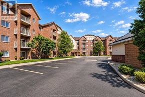 Windsor condo for rent - A sunny day at a residential area with apartment buildings and a parking lot.