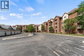 Windsor condo for rent - A parking lot in front of apartment buildings with a clear sky.