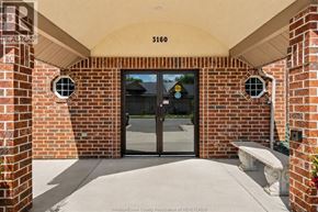 Windsor condo for rent - The entrance to a building with a glass door and a bench in front.
