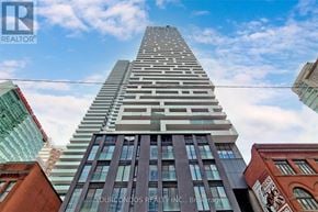 Toronto (Church-Yonge Corridor) condo for rent - A tall building with a sign that reads "You Condos Realty Inc., Brokerage" in front of it.