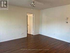 Toronto (Blake-Jones) condo for rent - A room with a ceiling fan and wooden floors.