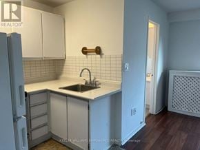Toronto (Blake-Jones) condo for rent - A kitchen with white cabinets and a white counter top.