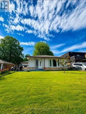 Toronto (York University Heights) apartment for rent - A house with a white exterior and a green lawn in front.