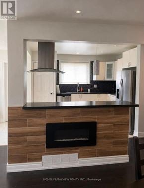 Toronto (York University Heights) apartment for rent - A modern kitchen with a fireplace and a stainless steel hood.