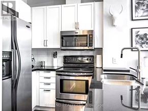 Toronto (Church-Yonge Corridor) condo for rent - A kitchen with white cabinets and stainless steel appliances.