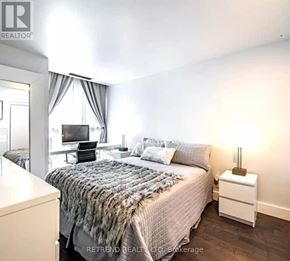 Toronto (Church-Yonge Corridor) condo for rent - A bedroom with a bed, nightstand, and a window with curtains.