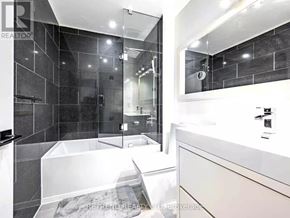 Toronto (Church-Yonge Corridor) condo for rent - A modern bathroom with a white tub and a walk-in shower.