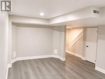 Mississauga (Applewood) townhouse for rent - A spacious room with a staircase in the background.